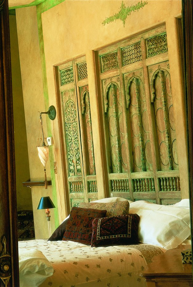 Carved panel serving as dramatic backdrop for the bed