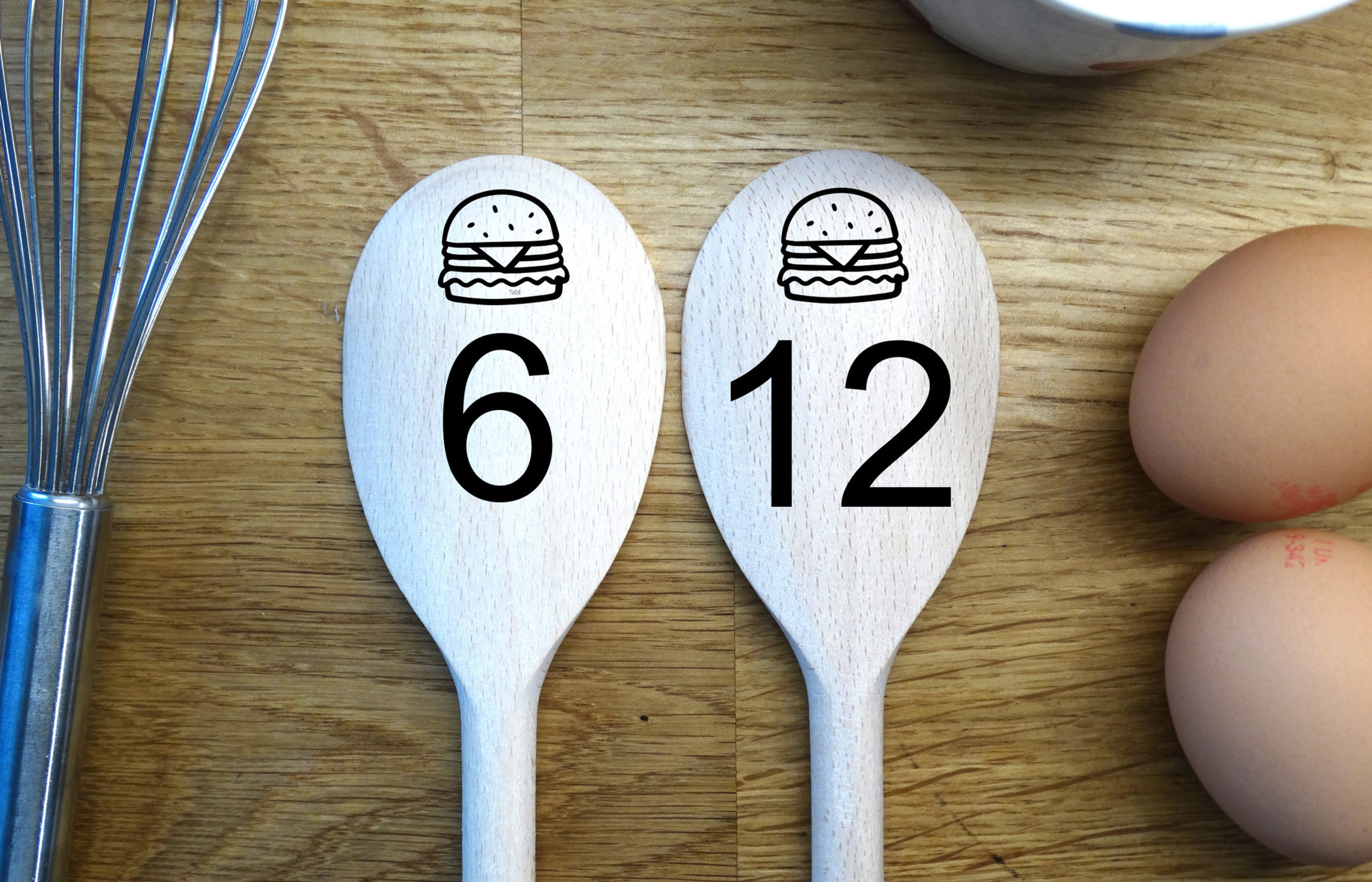 pair of wooden spoons with engraved burgers and then Table number and Order number. To show example as a table sign