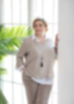 поза делового портрета с девушкой прямо и опирающейся спиной на стену