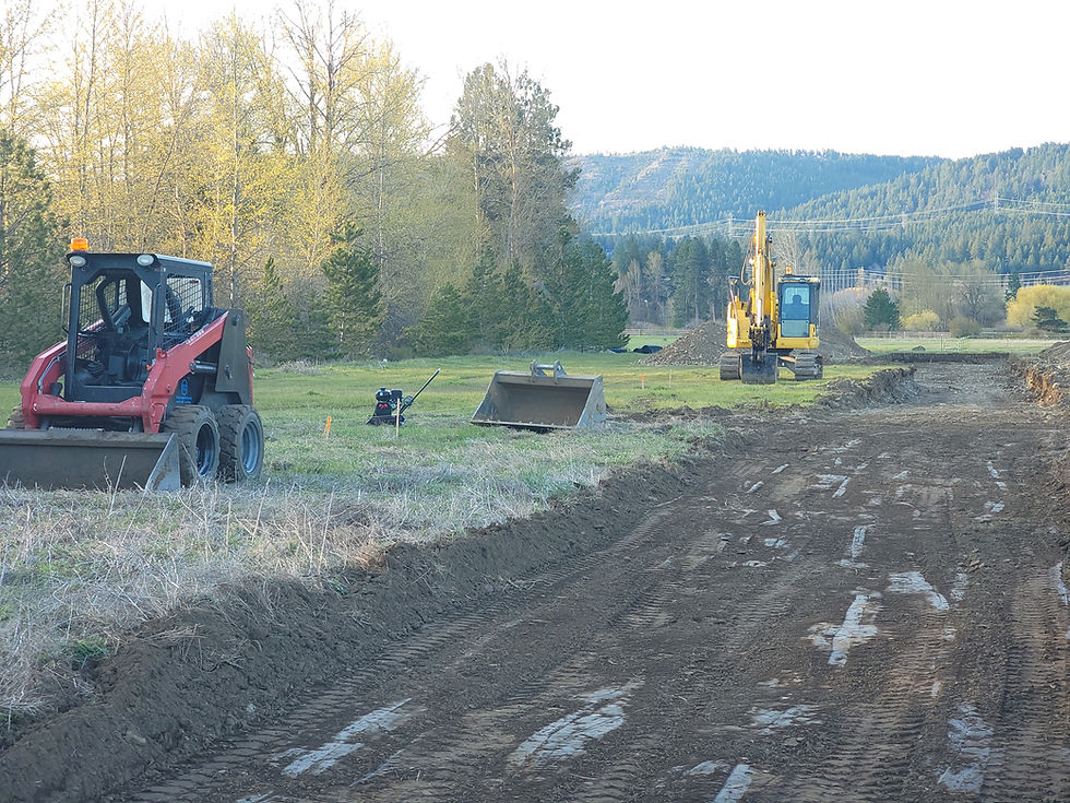 Cleared dirt lane with tractors next to it