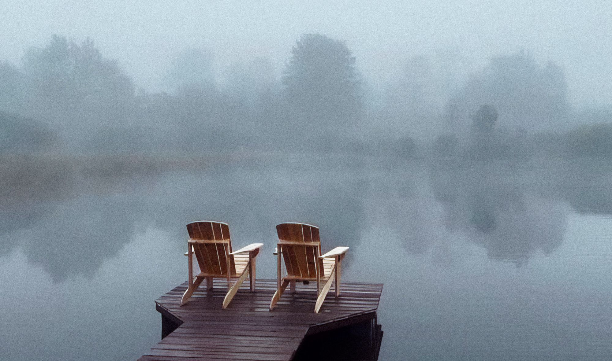 Two chairs on the dock in morning fog