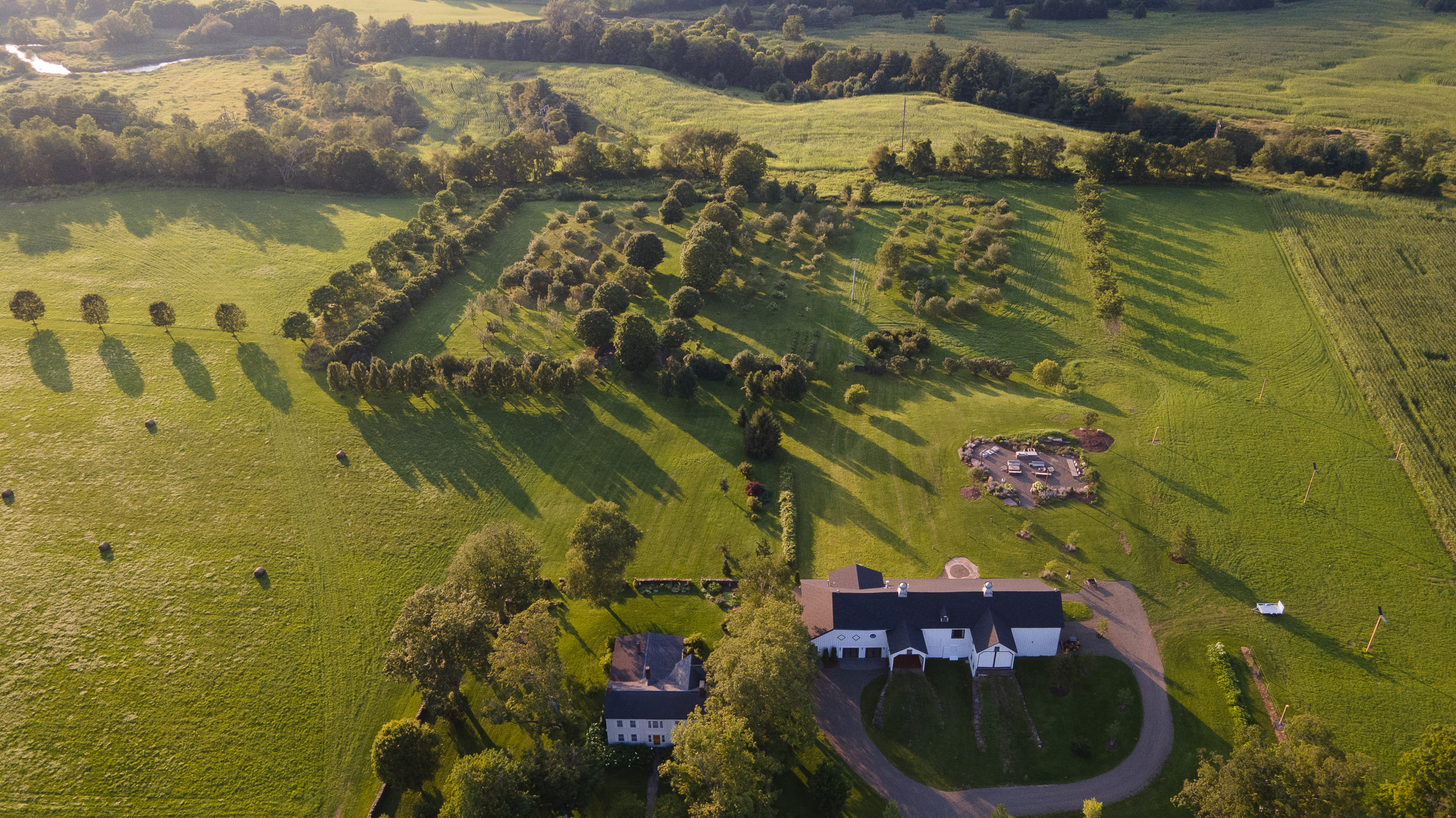 The property from the air: the road, the Barn, the farmhouse, the orchard, the fields, and the pond