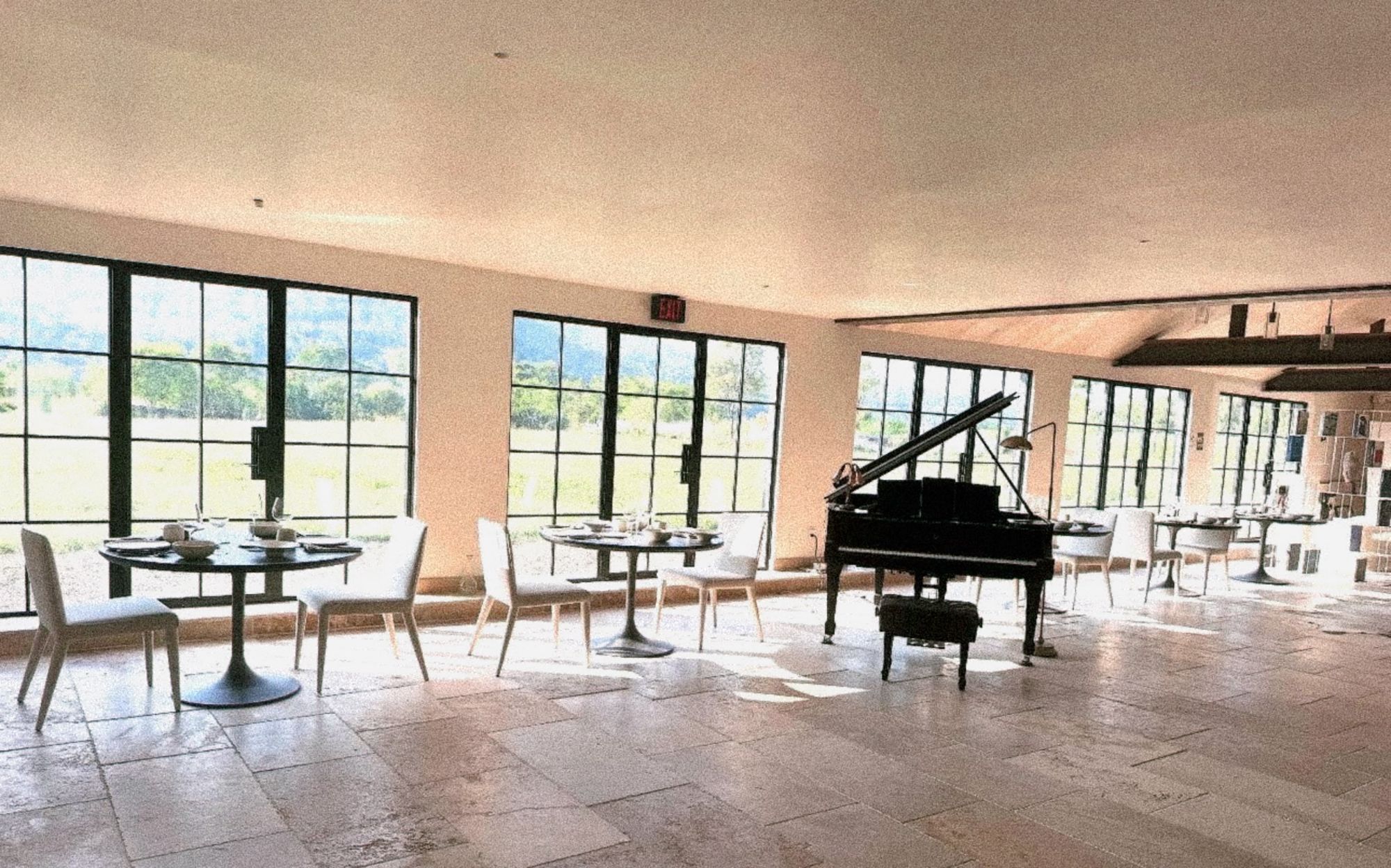 The travertine room set for a long lunch, mountains through the windows