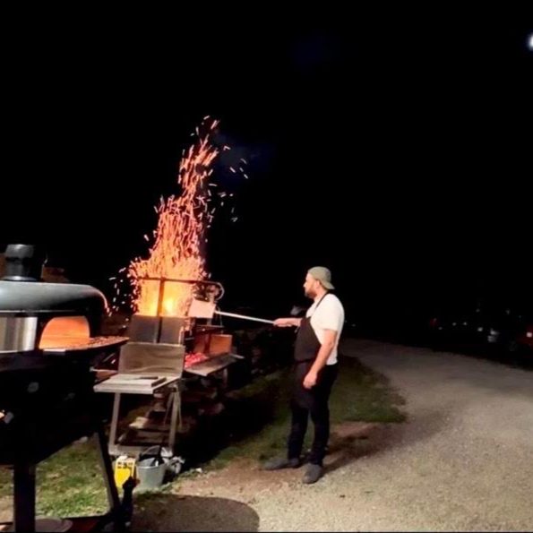Chef Will Johnson of Eighty Main working the fire after dark