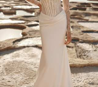 A sheer lace corset bodice with a draped satin skirt, from Natalie Rose Bridal's designer range.