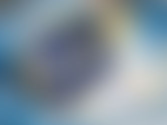 A blue United States passport standing slightly open on top of an unfolded world map, with visible entry stamps inside, suggesting international travel and mobility.