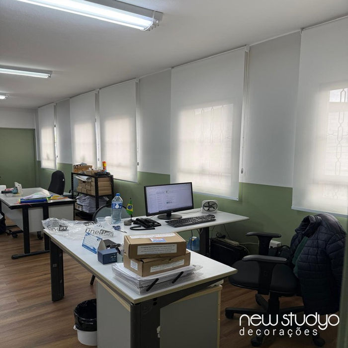 Persiana rolô tela solar branca em janela de escritório ao lado de computador e mesa de trabalho na Vila Olímpia.
