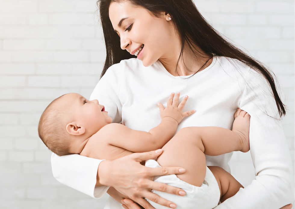 Vrouw in wit shirt houdt glimlachende baby vast. Witte achtergrond, warme en liefdevolle sfeer.
