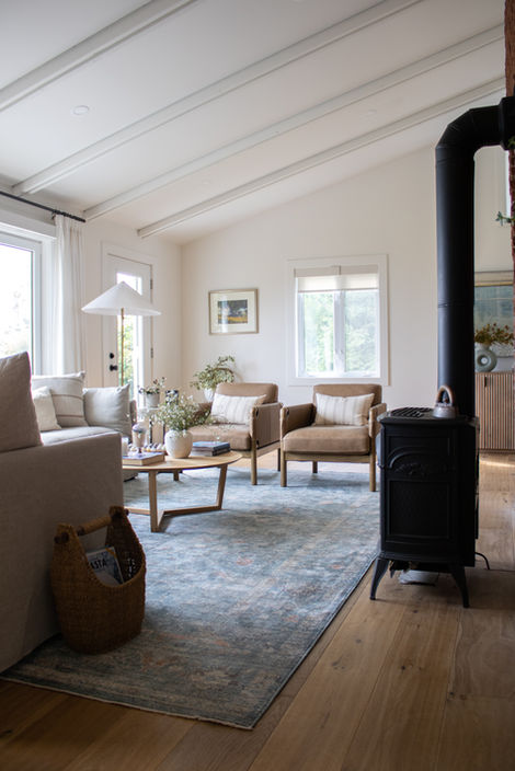 A wood stove sits to the right while the living room expands off to the left