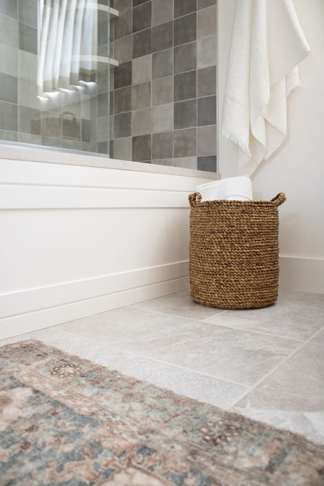 wicker basket in bathroom sits next to the tub to help with bathroom organization