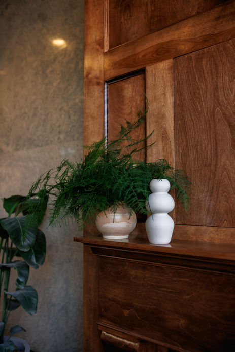Vases add a welcoming touch to this multi-unit building designed by Plank & Pine Interior Design