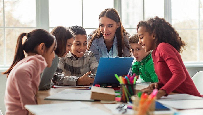 Teacher instructing a group of students, looking over a clipboard