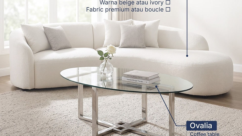 Sofa lengkung ivory di ruang tamu terang dengan meja tamu kaca Ovalia dan buku Interior Design Trends.