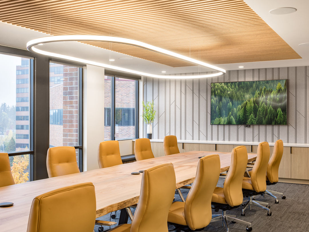 Modern conference room with wood table and ceiling.