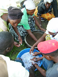 WOMEN AND STREET BOYS MAKING BRIQUETTES