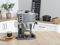 Home espresso machine set up on a kitchen counter with coffee cups