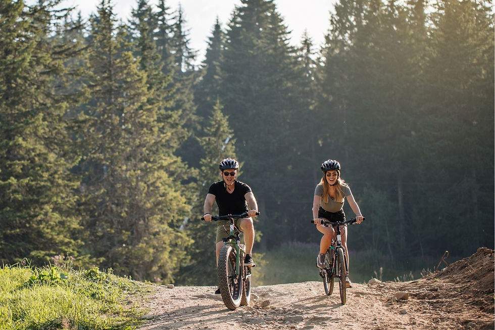 A couple riding a bike on a trail.