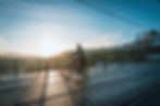 Person commuting on a regular bike across a bridge at sunrise.