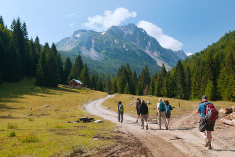 Group of travelers walking through a scenic natural trail, symbolizing low-impact, respectful tourism.