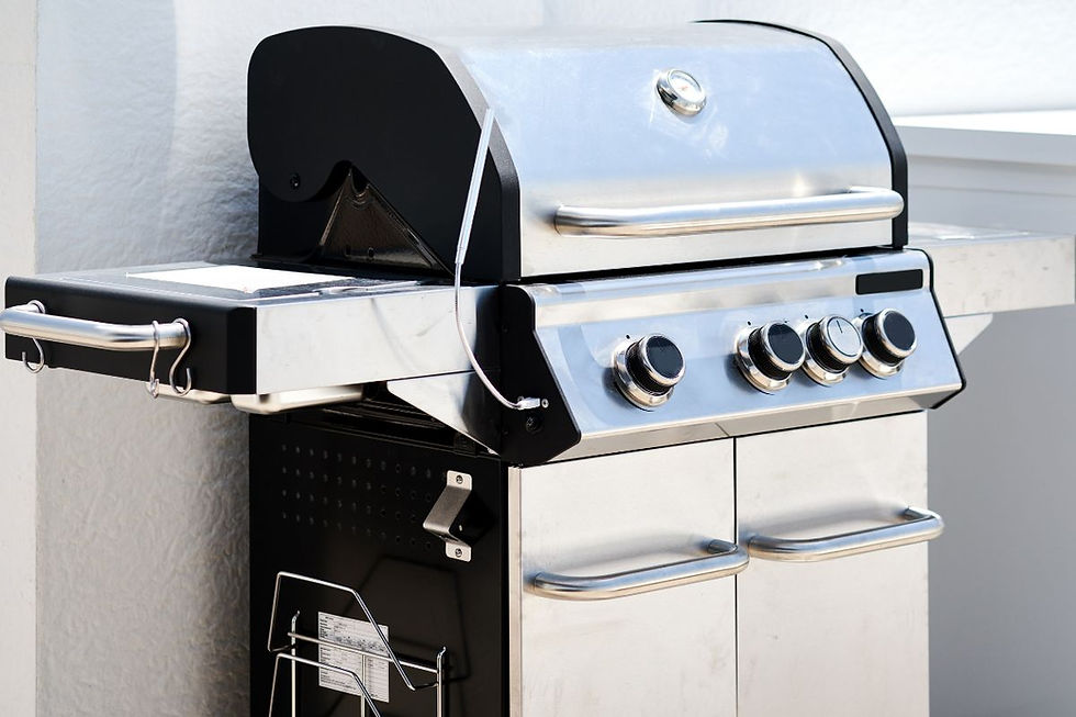 Premium stainless steel gas grill with multiple burners on a sunny backyard deck.
