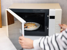 Plate of leftovers being reheated inside a microwave oven.