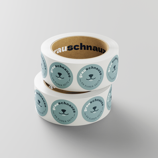 Sticker auf Rolle mit dem Logo der Grauschnauze. zwei Rollen gestapelt.
