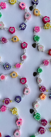 happy beads, kinderarmbandjes van kralen en polymeer kralen, bloemmotief. De kleuren geel, roze, oranje, groen, paars en wit