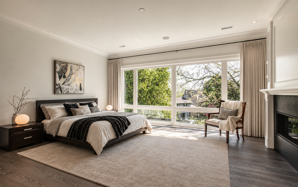 Bedroom with large windows and neutral bedding