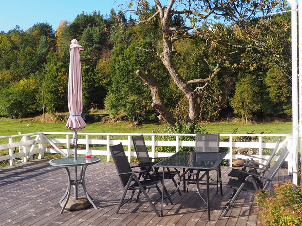 Ein großer Tisch mit Stühlen auf der schönen Terrasse mit wundervollem Blick ins Grüne.