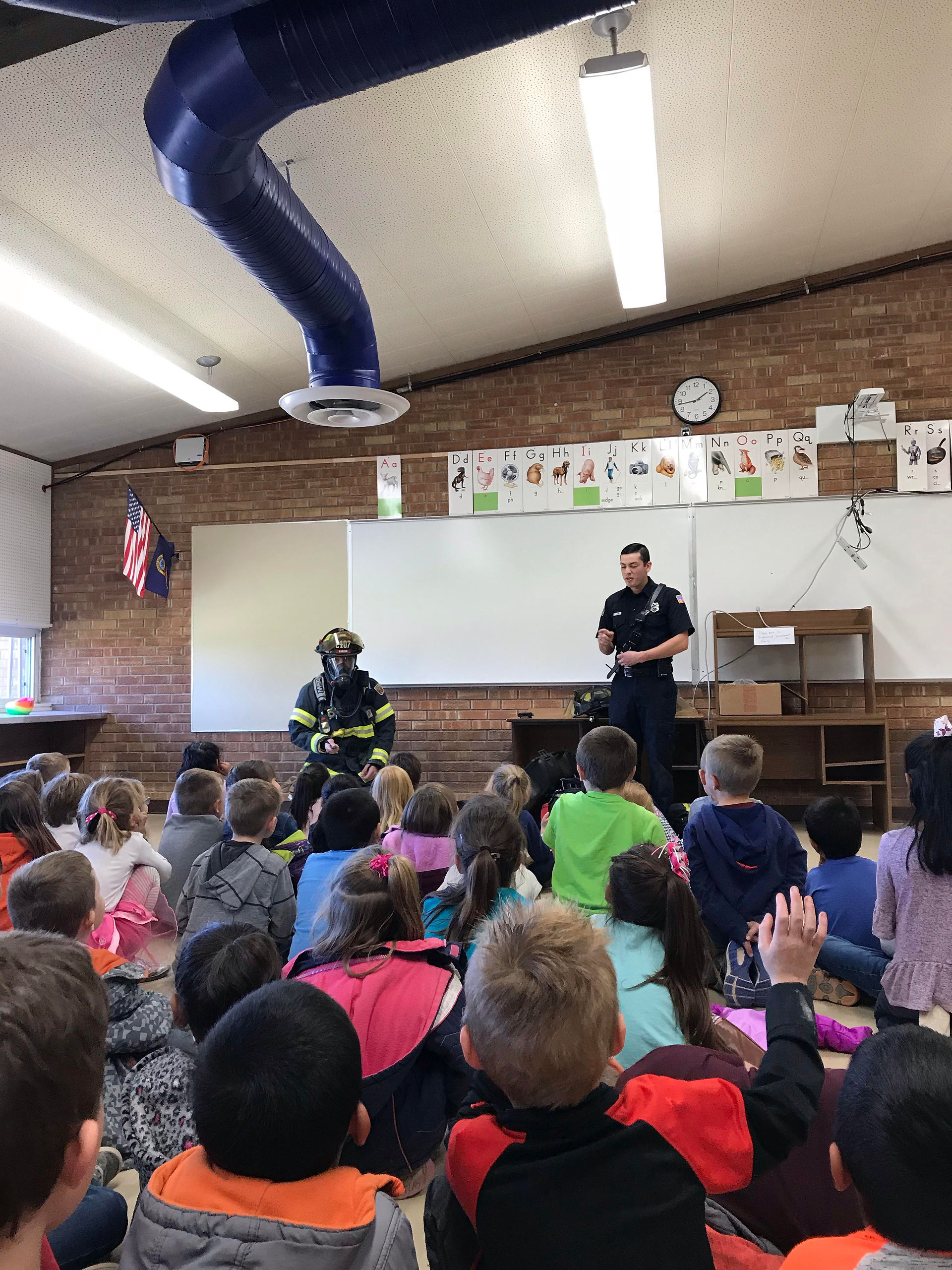Firefighters teach 2nd Grade students fire safety.