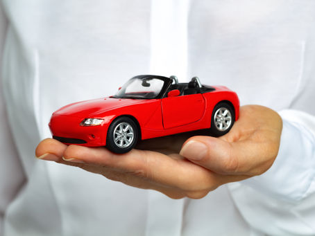 Man holding a red toy car