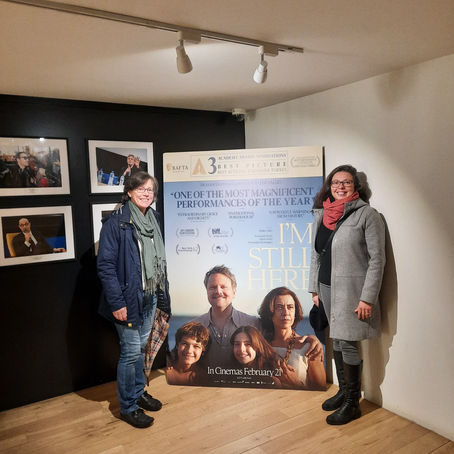 Two women standing at the poster of the film I'm Still Here (Ainda Estou Aqui) at one of the main cinemas of Dublin.