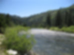 Mountains, under blue sky, with a wide river below