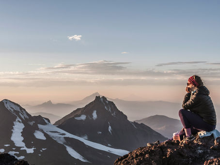 woman sitting on mountain top