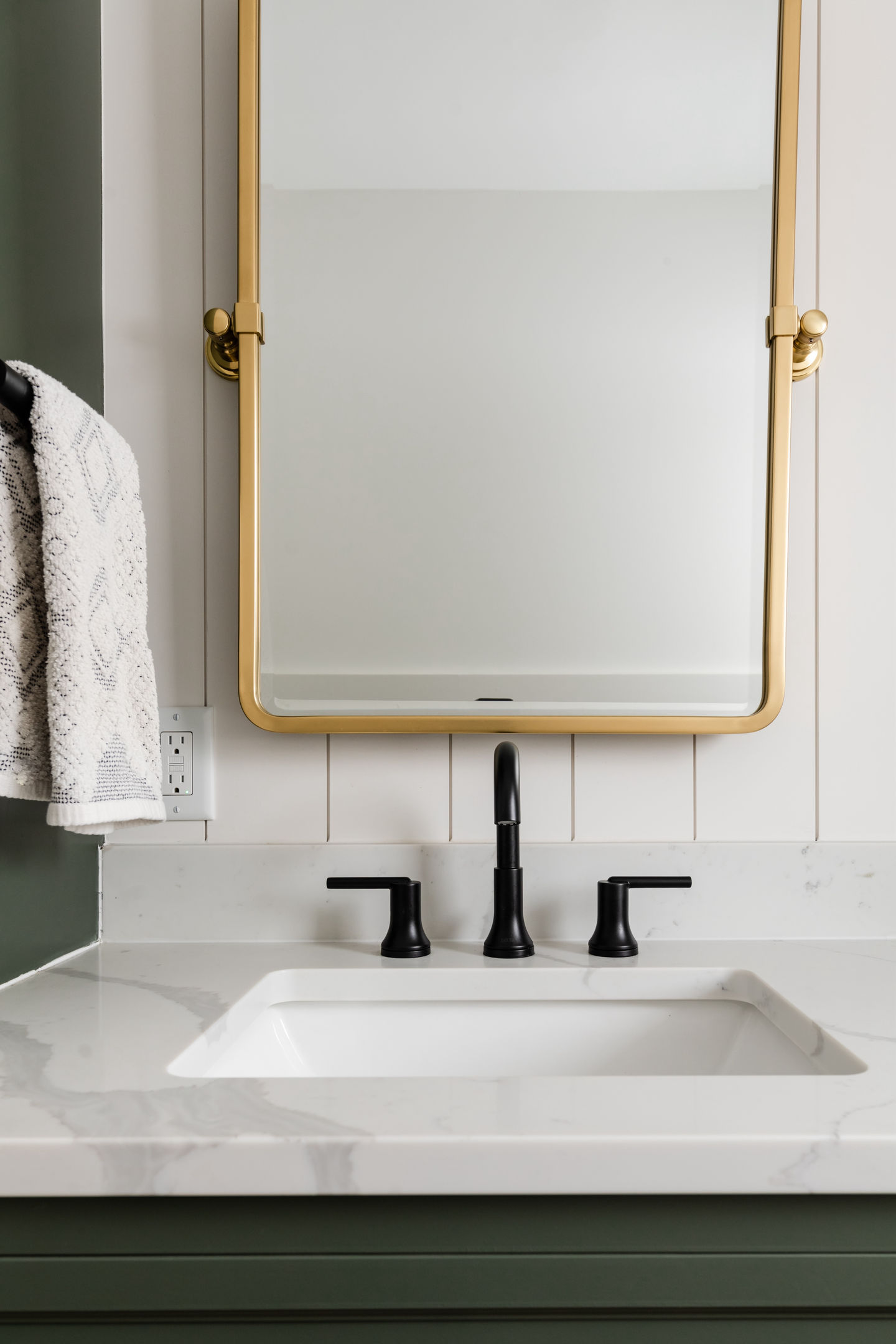 Edina Minnesota custom interior remodeled bathroom featuring custom green painted cabinets, white painted shiplap walls, white quartz counter top, and gold hardware accents
