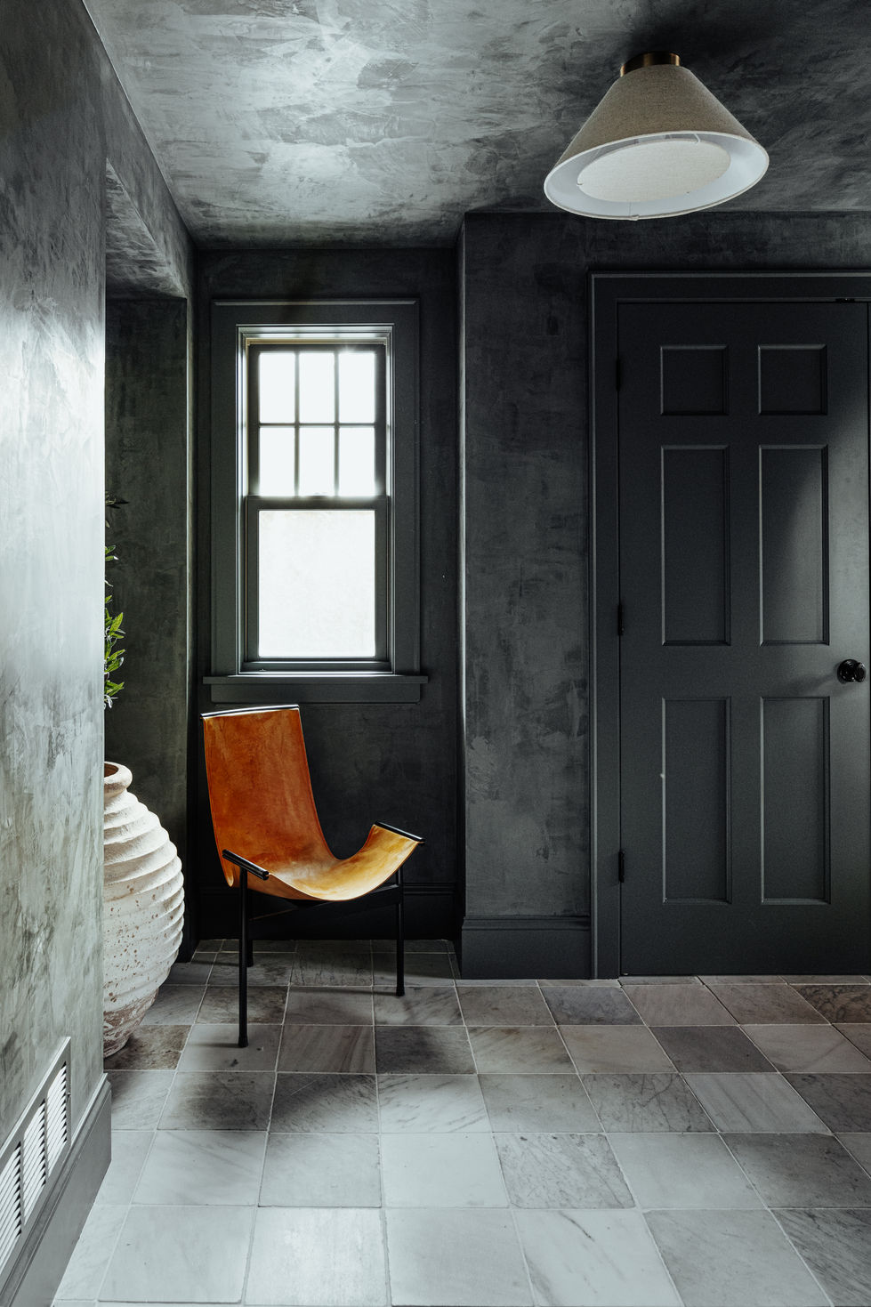 Edina mudroom remodel feturing custom green Portola Roman clay plaster walls, color matched painted trims and doors, imported Italian vintage marble tile squares, and venetian plaster.