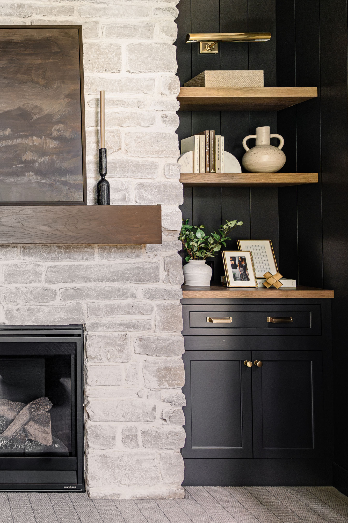 Custom Minneapolis office remodel featuring spray painted satin black shiplap, custom built in cabinetry, stone fireplace, floating white oak shelving, main center wood ceiling beam, and a quartz desk top