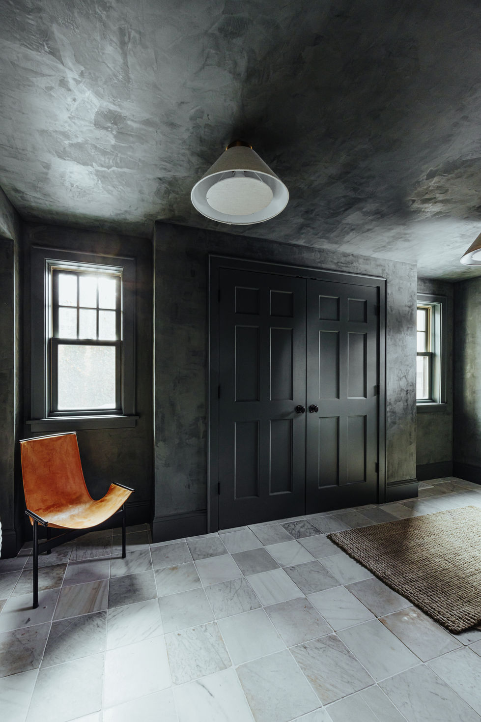 Edina mudroom remodel feturing custom green Portola Roman clay plaster walls, color matched painted trims and doors, imported Italian vintage marble tile squares, and venetian plaster.