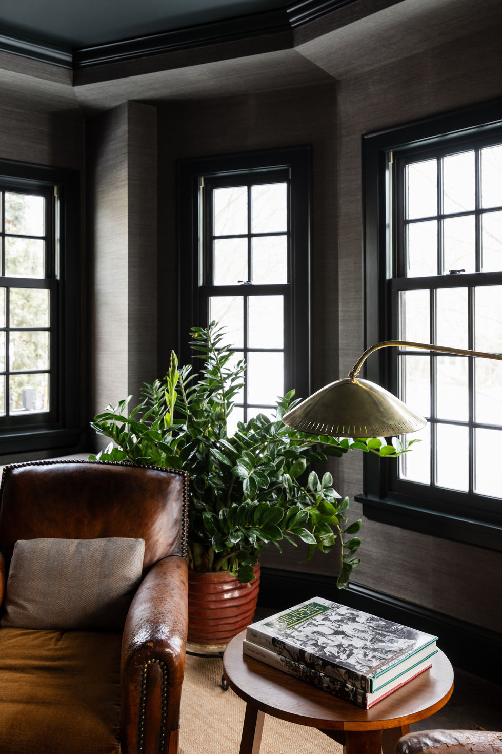 Edina Minnesota interior home remodel featuring a custom painted green office study with designer styled book shelving, raised tray ceiling with custom painted green crown molding, gray wallpaper, and new leather chairs