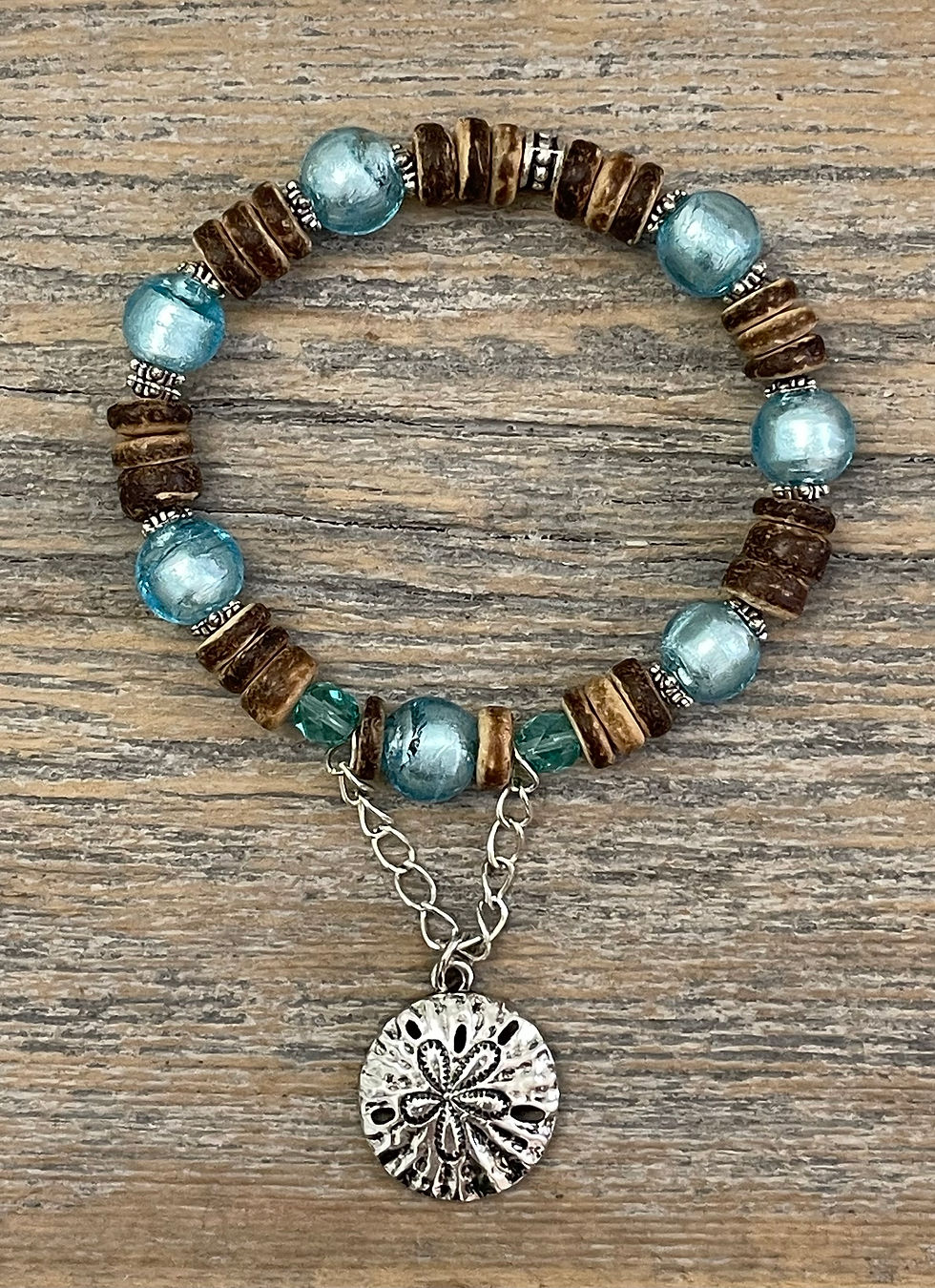 Thumbnail: Driftwood Cove bracelet with aqua art glass, wood rondelle beads, and a silver sand dollar charm.