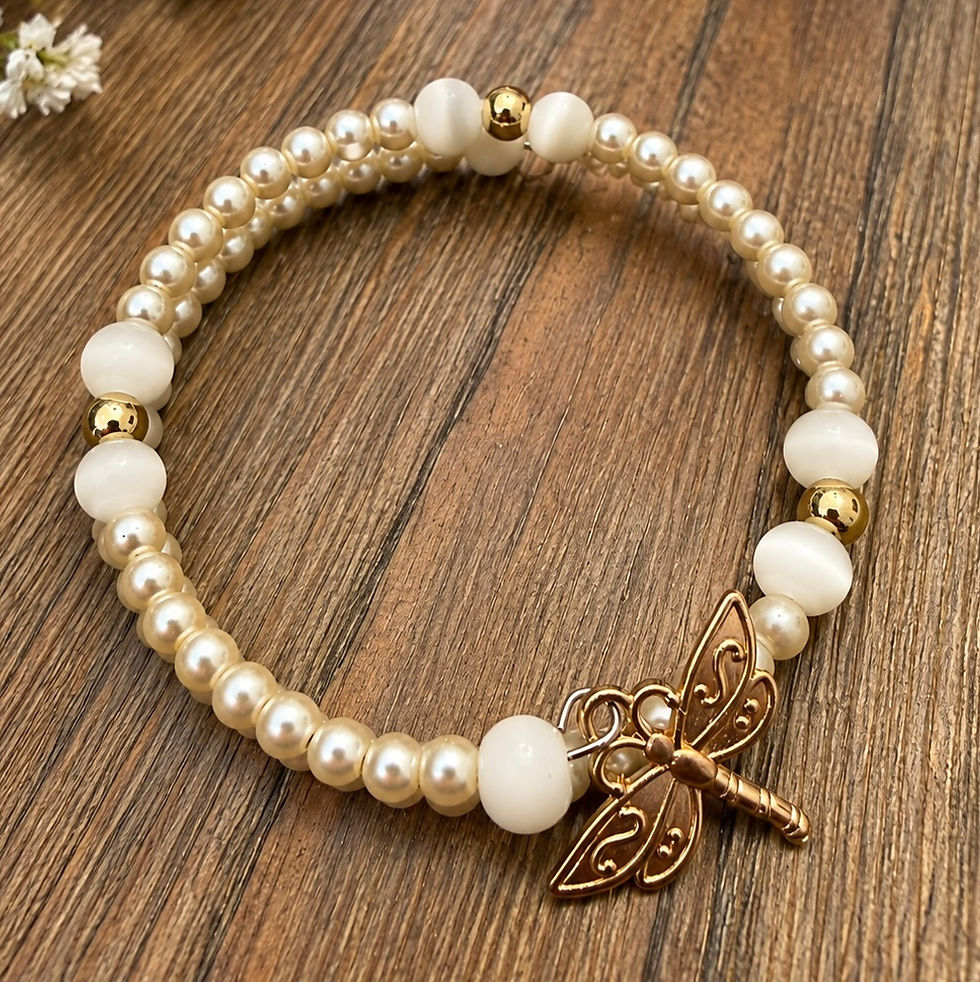 Dust & Gold two-row pearl memory wire bracelet with creamy white beads, gold-tone accents and a detailed gold dragonfly charm