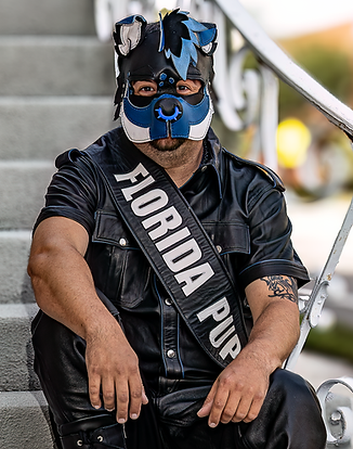 Pup Badru, has been in the leather and kink community for over 15 years. Started their journey in slave training to a mistress, soon found the puppy community and knew it was their true calling. Since then Pup Badru has sought for a more inclusive community where we all accept each other for who we are no matter how different we are. Pup Badru was Florida Puppy 2024 and is the founder of the Puppy and Critter Community Archives. 
They spend most their time volunteering for events, Producing Florida Puppy and Pet Weekend, and trying to make the community a better place for all. Pup Badru is an educator and has discussion classes on head-space and its mental health benefits. They are also a firm believer that an alpha is just a handler in head-space, and that some days we must take off our hoods and be the handlers our community needs.
