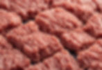 Raw portions of ground meat arranged in a uniform pattern.