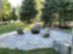 an outdoor stone patio in the shade of trees