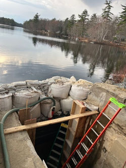 Sandbags holding back water. Stop log work.