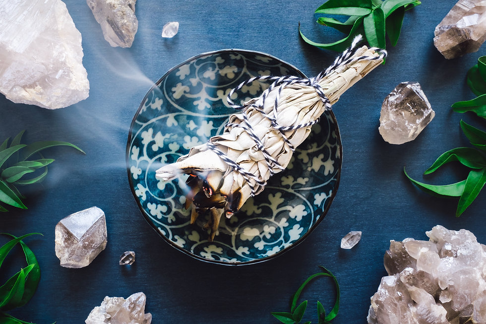 smudge stick smoldering in a ceramic bowl surrounded by crystals
