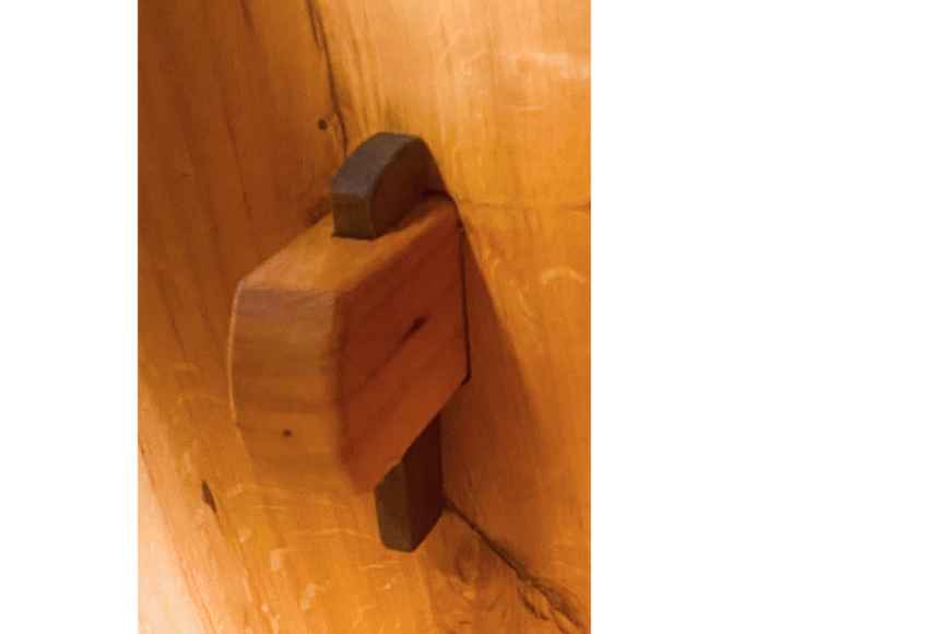 Detail of hand-driven walnut wedge on trestle of oak table leg