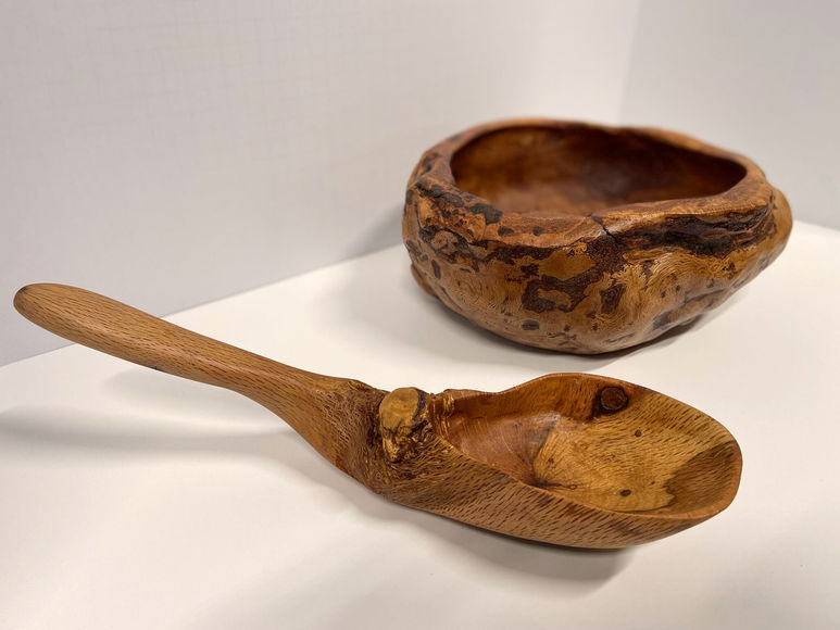 Rustic bowl and spoon carved from a burl, displaying natural contours and tree deformities, side view, spoon and bowl shown next to each other
