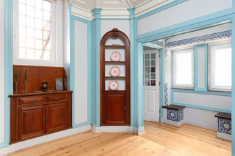 Interior view connecting rooms through glass-panel doors, decorative dish niche, and traditional wood joinery restored by Bustorff Workshop in Lisbon.