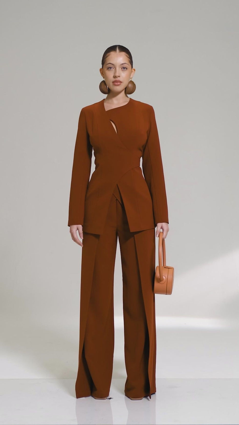 woman in brown business attire holding a brown purse